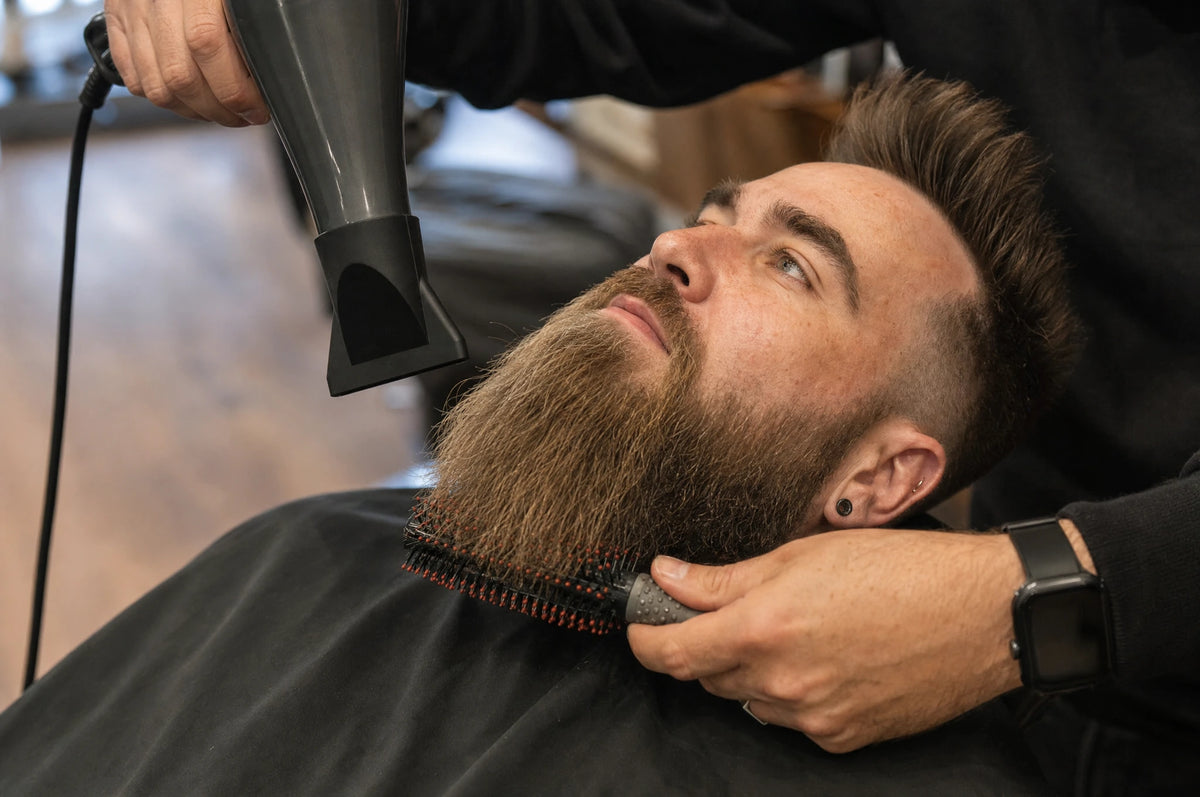 Barbier séchant et brossant la longue barbe d’un client incliné